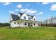 White farmhouse with gray roof, large windows, and a wrap-around porch at 1026 Walker Branch Rd, Lincolnton, NC 28092