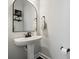 Clean powder room with pedestal sink and arched mirror at 1248 Thomas Knapp Pkwy, Fort Mill, SC 29715