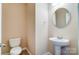 Small bathroom with pedestal sink and round mirror at 13441 Calloway Glen Dr, Charlotte, NC 28273