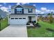 Two-story house with a two-car garage and landscaped lawn at 179 Tanner Loop, Troutman, NC 28166