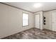 A bright bedroom features wood-look floors, neutral walls, and a window at 1805 Drew Dr, Lincolnton, NC 28092