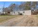 Lovely one-story home with gray siding, black shutters, and large grassy front yard and a dirt driveway at 1805 Drew Dr, Lincolnton, NC 28092