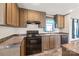 Kitchen with wood cabinets, dark countertops, black appliances, and a window over the sink at 1805 Drew Dr, Lincolnton, NC 28092