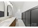 Elegant bathroom with double vanity, bathtub and dark wainscoting at 210 S Millon St, Gastonia, NC 28052