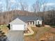 Gray house with attached garage, stone accents, and walkway leading to front door at 34466 Lisa Dr, Albemarle, NC 28001