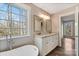 Spa-like bathroom with double vanity, granite countertop, and a bathtub at 34466 Lisa Dr, Albemarle, NC 28001