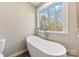 Relaxing bathroom with a free-standing bathtub and large window at 34466 Lisa Dr, Albemarle, NC 28001