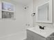 Updated bathroom with gray vanity, white tub, and new fixtures at 4421 Gum St, Charlotte, NC 28208