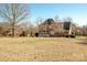 Large backyard with mature trees and home view at 5023 Ancestry Cir, Matthews, NC 28104