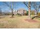 Two-story brick home with manicured lawn and mature trees at 5023 Ancestry Cir, Matthews, NC 28104