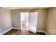 Bedroom with wood-look flooring, natural light, and open door to another room at 5917 Peach St, Charlotte, NC 28269