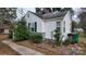 Side view of a white house with gray brick base and landscaping at 5917 Peach St, Charlotte, NC 28269