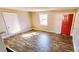 Living room featuring wood-look flooring, a window and bright red front door at 5917 Peach St, Charlotte, NC 28269