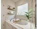 Bathroom with soaking tub and marble tile, with adjacent shelving at 6142 Cloverdale Dr, Tega Cay, SC 29708