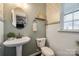 Small powder room with pedestal sink, decorative wallpaper, and a toilet at 6142 Cloverdale Dr, Tega Cay, SC 29708