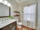 Clean bathroom with floating shelves, white vanity, and wood floors at 6608 Brookgreen Ter, Matthews, NC 28104