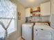 Bright laundry room with washer, dryer, and ample storage at 6608 Brookgreen Ter, Matthews, NC 28104