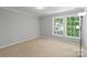 A bright bedroom features neutral walls, carpet, and large windows for natural light at 7019 Walnut Ridge Ct, Charlotte, NC 28217