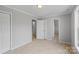 A large bedroom with neutral carpet features a doorway to the bathroom and a closet at 7019 Walnut Ridge Ct, Charlotte, NC 28217
