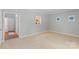 A spacious carpeted living room features a decorative window accent, neutral walls, and a doorway to a hardwood floored room at 7019 Walnut Ridge Ct, Charlotte, NC 28217