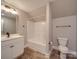 Modern bathroom with a white vanity, tub, toilet, and wood-look tile floor at 721 Red Spruce Dr, York, SC 29745