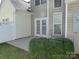 A backyard patio featuring a set of french doors and a manicured green bush at 8620 Robinson Forest Dr, Charlotte, NC 28277