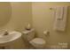 Half bathroom with tile floor, white fixtures, and modern design at 8620 Robinson Forest Dr, Charlotte, NC 28277