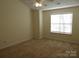 A sunny bedroom featuring neutral walls, carpeting, ceiling fan, and a window for natural light at 8620 Robinson Forest Dr, Charlotte, NC 28277