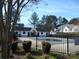 Community pool surrounded by a fence and lush landscaping on a sunny day at 8620 Robinson Forest Dr, Charlotte, NC 28277