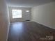 Bright living room featuring hardwood floors, neutral paint, a front door and large window at 8620 Robinson Forest Dr, Charlotte, NC 28277