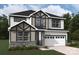 Two-story house with gray and white exterior, stone accents, and a three-car garage at 9957 Cask Way, Huntersville, NC 28078