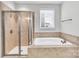 Well-lit bathroom featuring a soaking tub and glass-enclosed shower at 1037 Tobin Dr, Fort Mill, SC 29715