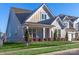 Gray house with a white front door and a large front porch.Landscaped lawn at 1037 Tobin Dr, Fort Mill, SC 29715