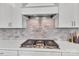 Gas cooktop with white shaker cabinets and a stone backsplash at 1037 Tobin Dr, Fort Mill, SC 29715