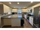 Modern kitchen with white cabinets, stainless steel appliances, and gray countertops at 108 Greenview Dr, Kannapolis, NC 28081