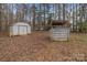 Features a storage shed and wooden structure amidst a wooded backyard with mature trees at 114 Catawba Woods Ct, Belmont, NC 28012