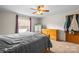 Bedroom with wooden dresser, ceiling fan, large window, and closet offering storage and natural light at 114 Catawba Woods Ct, Belmont, NC 28012