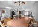 Open dining area featuring hardwood floors, a ceiling fan, and natural light; adjoining kitchen and living room at 114 Catawba Woods Ct, Belmont, NC 28012