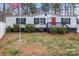 Charming single-story home with white siding, black shutters, a vibrant red door, and an American flag at 114 Catawba Woods Ct, Belmont, NC 28012