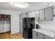 Efficient kitchen layout with black refrigerator, gray cabinets, and adjacent laundry area at 114 Catawba Woods Ct, Belmont, NC 28012