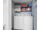 Convenient laundry area equipped with white washer and dryer and storage shelves at 114 Catawba Woods Ct, Belmont, NC 28012