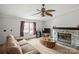 Cozy living room featuring a stone fireplace, ceiling fan, and comfortable seating at 114 Catawba Woods Ct, Belmont, NC 28012