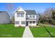 Two-story house with a gray door, white siding, and a landscaped lawn at 114 E 5Th Ave, Gastonia, NC 28052