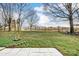 Large grassy backyard with mature trees and a partially visible fence at 129 Bald Cypress Ln, Mooresville, NC 28115