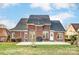 Brick home with backyard patio, grill, and yard at 129 Bald Cypress Ln, Mooresville, NC 28115