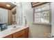 Clean bathroom with wood vanity and window at 129 Bald Cypress Ln, Mooresville, NC 28115