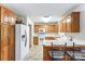 Kitchen with wood cabinets, white appliances, and breakfast bar at 129 Bald Cypress Ln, Mooresville, NC 28115