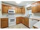 Kitchen with wood cabinets, white appliances and large window at 129 Bald Cypress Ln, Mooresville, NC 28115