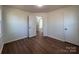 A simple bedroom featuring wood flooring, neutral paint, and a door leading to another room at 1325 Eastview Ext, Shelby, NC 28152