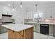 Modern kitchen with white cabinets, quartz countertops and a statement island at 13833 Jonathans Ridge Rd, Charlotte, NC 28227